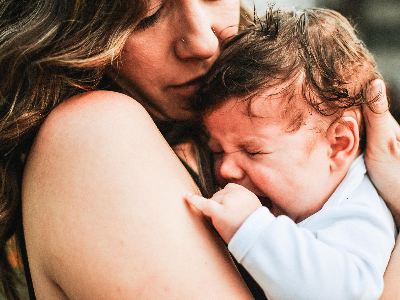 Baby weint auf Mamas Arm