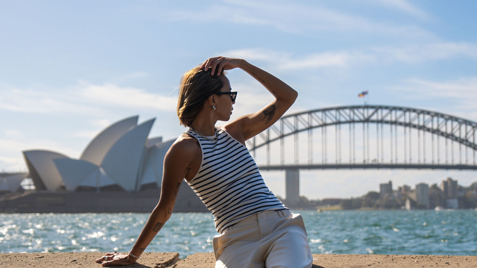 A woman looking towards the Sydney Harbour Bridge and Sydney Opera House