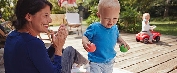 Mutter und Kleinkind spielen im Garten