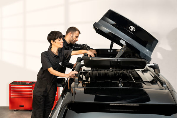 two people working on a Toyota car
