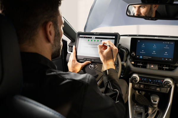 Toyota technician on tablet in driving seat